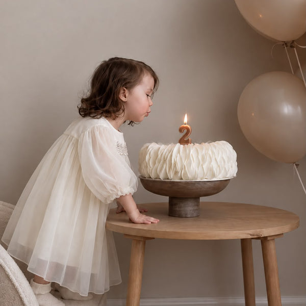 Niña soplando velas de cumpleaños con Celebration Dress
